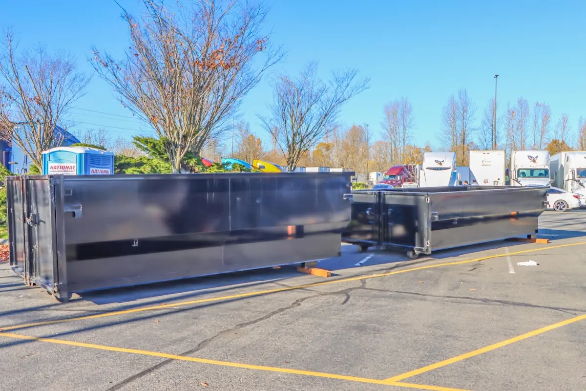 Professional dumpster rental service with roll-off container on residential driveway in Rensselaer